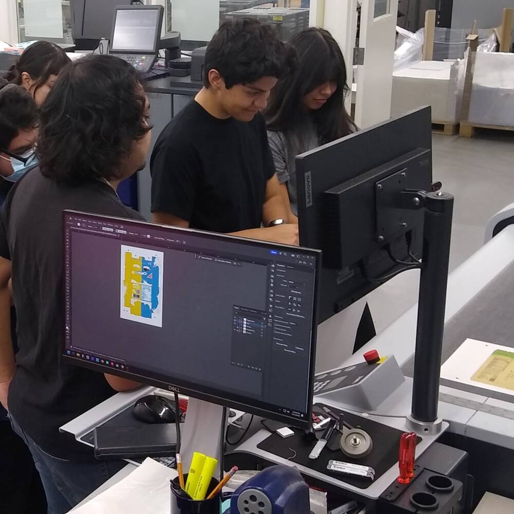 Applied Digital Media & Printing students observing the speed and precision of the Zund S3 M-800 in action. RCC-Students-Zund-01_16-9