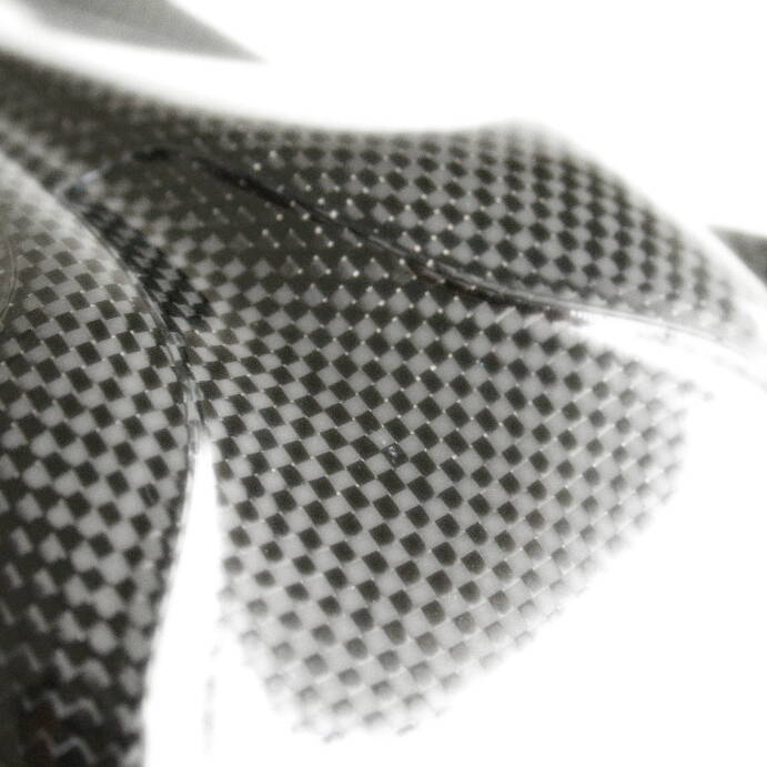Close-up of a carbon fiber composite material with a checkered pattern, showcasing its texture and glossy finish. Close-up of a carbon fiber composite material with a checkered pattern, showcasing its texture and glossy finish.