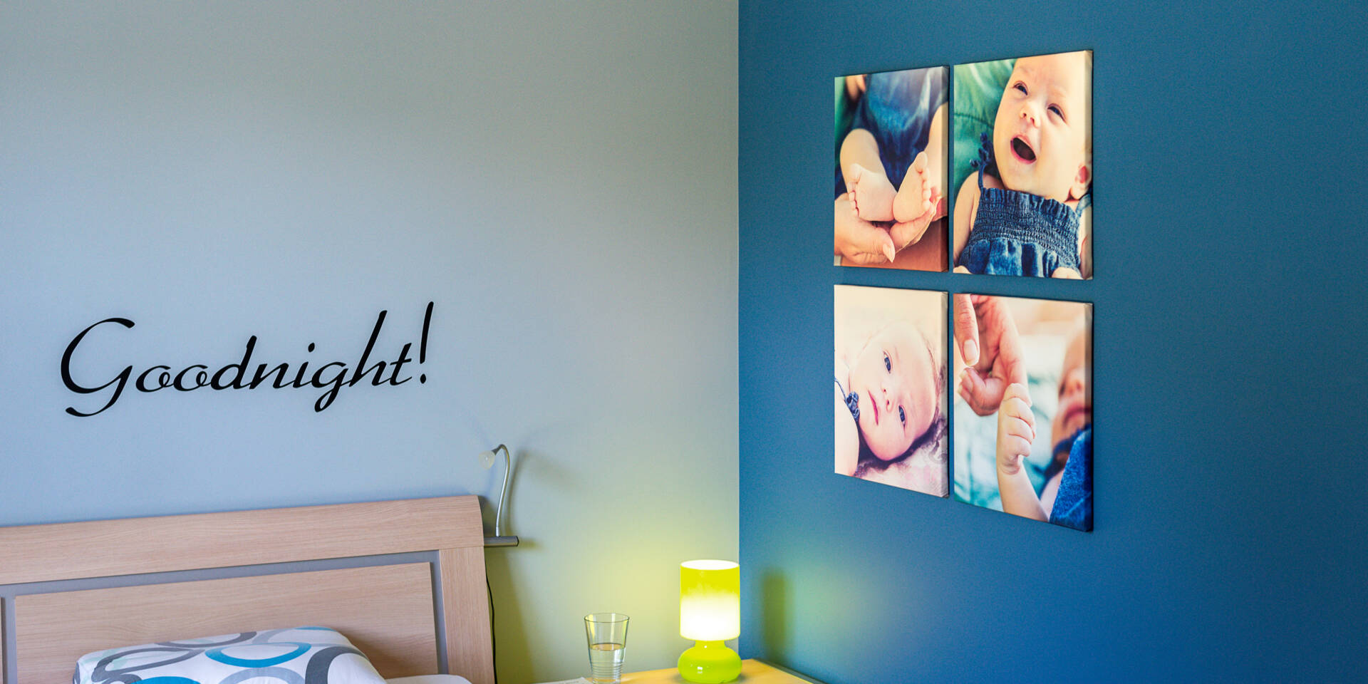 Een slaapkamer met de tekst 'Goodnight!' en vier canvasfoto's van baby's aan de muur.