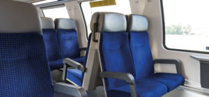 Innenansicht von blauen Zugsitzen mit Kopfstützen und Armlehnen, Sitzreihen im Abteil, Fenster mit Blick nach draußen. Innenansicht von blauen Zugsitzen mit Kopfstützen und Armlehnen, Sitzreihen im Abteil, Fenster mit Blick nach draußen.