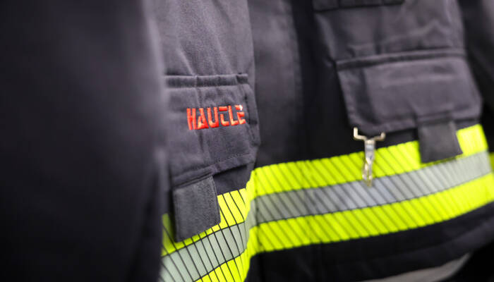 Detailansicht von Schutzkleidung mit Hautle-Logo und strapazierfähigem Stoffmaterial.