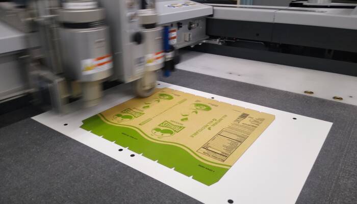 Zünd S3 M-800 digital cutter equipped with cutting and creasing tools processing folding carton, converting a student-designed print & cut file into a foldable box. RCC-Students-Zund-02