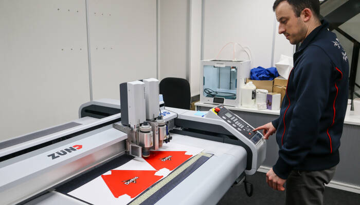 Zund-S3-Cutter-in-the-Alexir-Company-with-employee-in-front