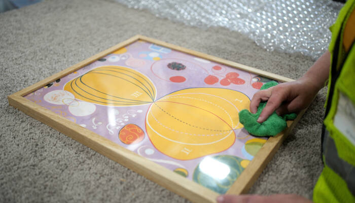 Finishing touches are applied to framed fine-art print before packaging. Finishing touches are applied to framed fine-art print before packaging.