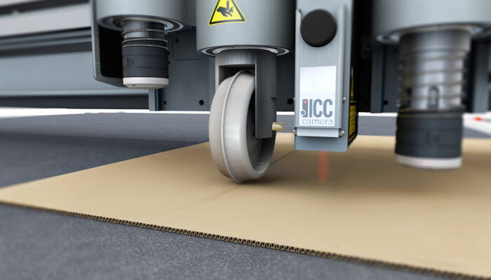Zünd ICC camera system precisely guiding a creasing tool onto corrugated cardboard for accurate material processing.