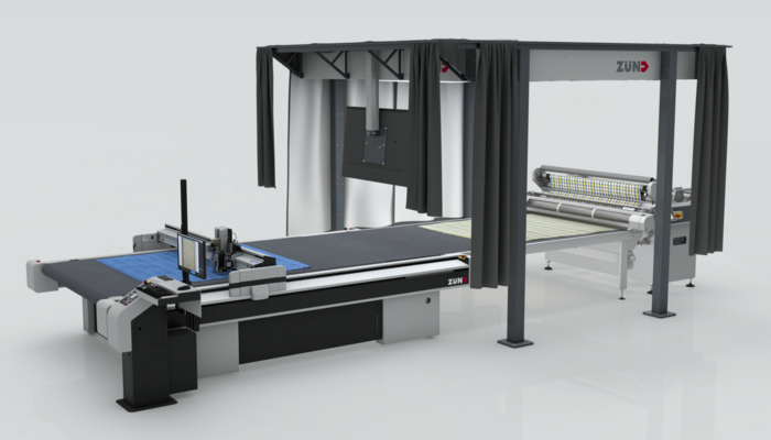 Support rack for optimal lighting conditions during material capture—one of many technological innovations on display at Zünd Booth D78 in Hall 8. Industrial Zünd flatbed cutter with roll-fed material feed and a shielded, illuminated work area for error-free material detection
