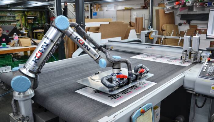 Der nachträglich integrierte Roboterarm sorgt für mehr Effizienz und zugleich Entlastung der Maschinenführer. Kaltenkirchen_Insign_Zünd_(5)