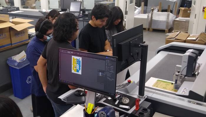 Applied Digital Media & Printing students observing the speed and precision of the Zund S3 M-800 in action. RCC-Students-Zund-01_16-9