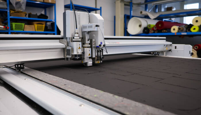 Kevlar- und Aramid-verstärkte Spezialtextilien wie Nomex sind äusserst anspruchsvoll im Zuschnitt. Detailaufnahme eines Schneidkopfs auf einem digitalen Flachbettcutter von Zünd.