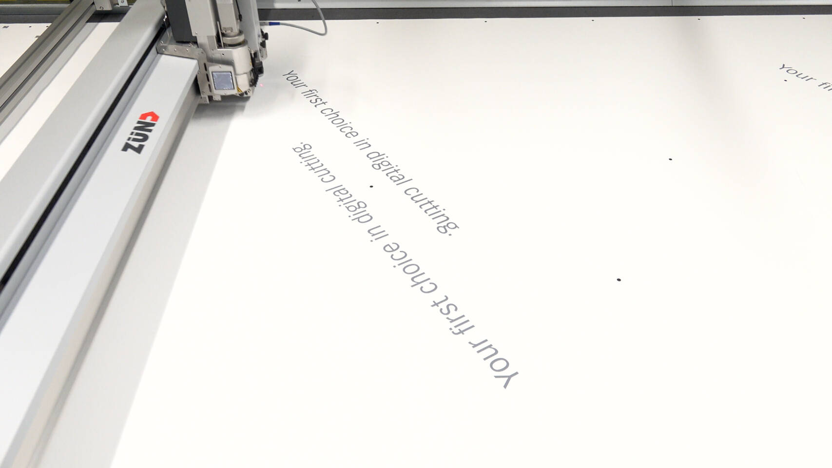 ZÜND logo on a digital cutting machine precisely cutting 'Your first choice in digital cutting' text. ZÜND logo on a digital cutting machine precisely cutting 'Your first choice in digital cutting' text.
