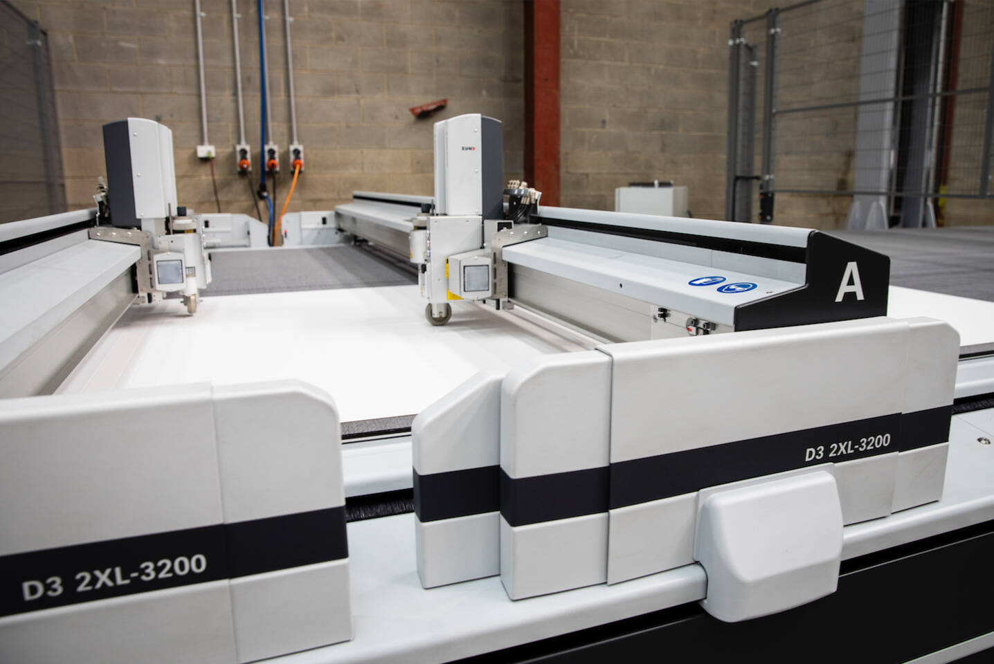 Z&uuml;nd D3 2XL-3200 digital cutting machine with two cutting heads on a white surface in a factory setting.