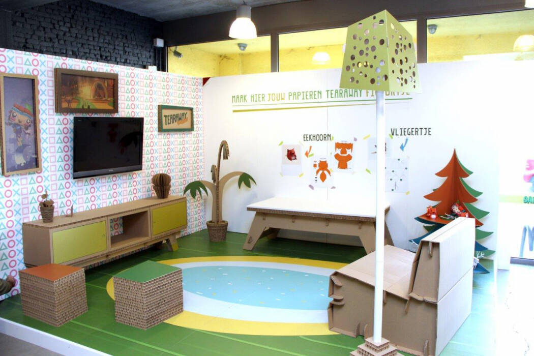 Een speelse, kindvriendelijke display met kartonnen meubels, decoraties en muurkunst, inclusief een tv en zitjes. Een speelse, kindvriendelijke display met kartonnen meubels, decoraties en muurkunst, inclusief een tv en zitjes.