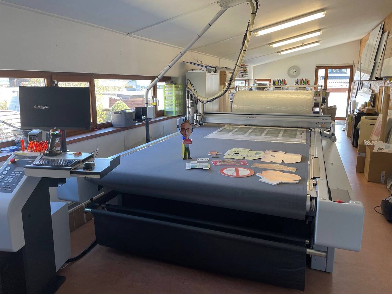 Zünd snijplotter met een computer, muis, toetsenbord en diverse gesneden materialen op het snijbed. Zünd snijplotter met een computer, muis, toetsenbord en diverse gesneden materialen op het snijbed.