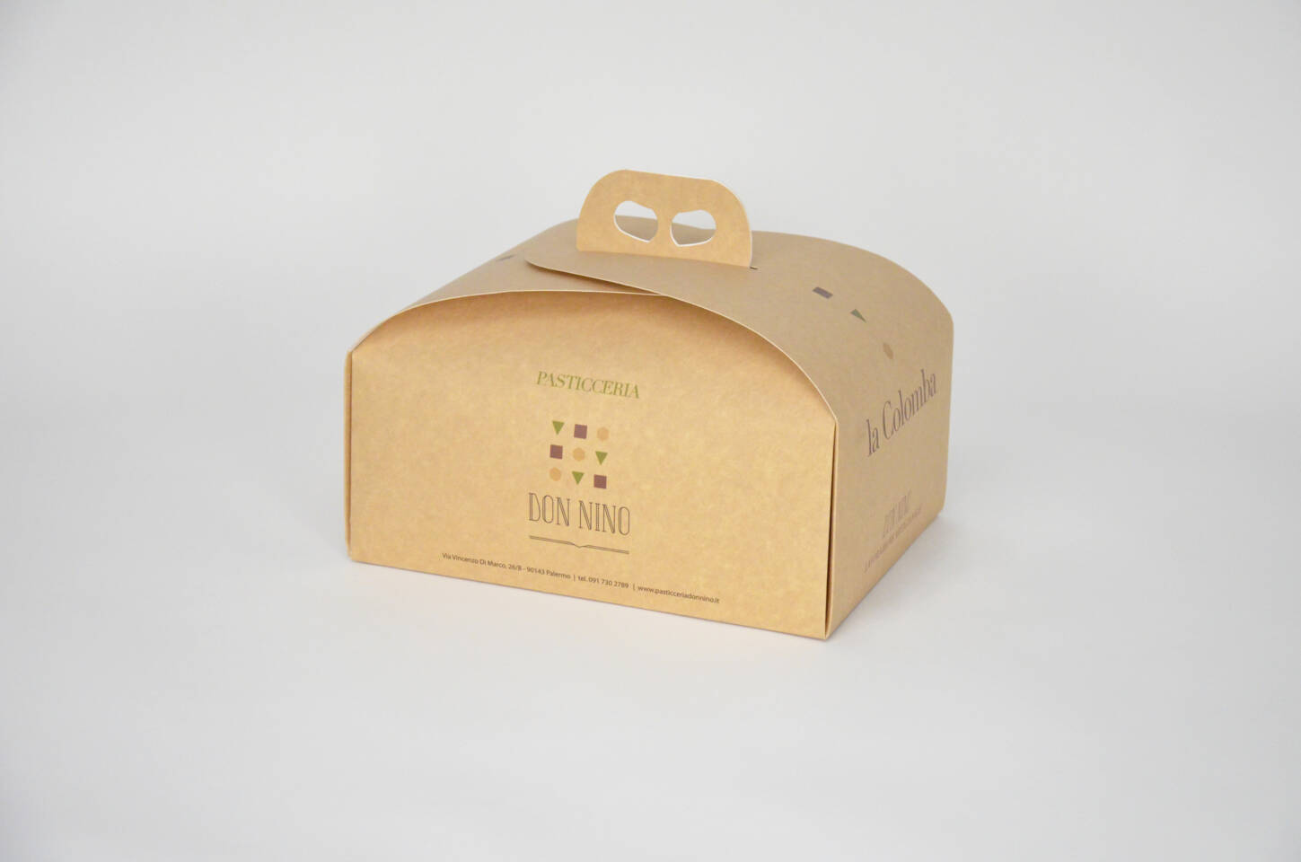 Scatola per dolci in cartone con logo 'Don Nino Pasticceria' e 'La Colomba', su sfondo bianco.