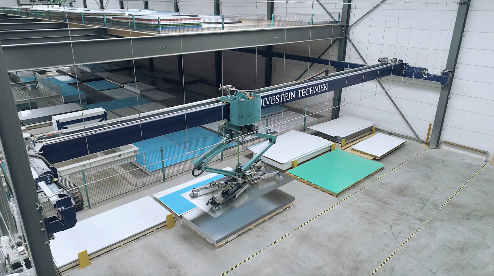Zünd vacuümheffer tilt en plaatst grootformaat platen in een industrieel magazijn. Zünd vacuümheffer tilt en plaatst grootformaat platen in een industrieel magazijn.