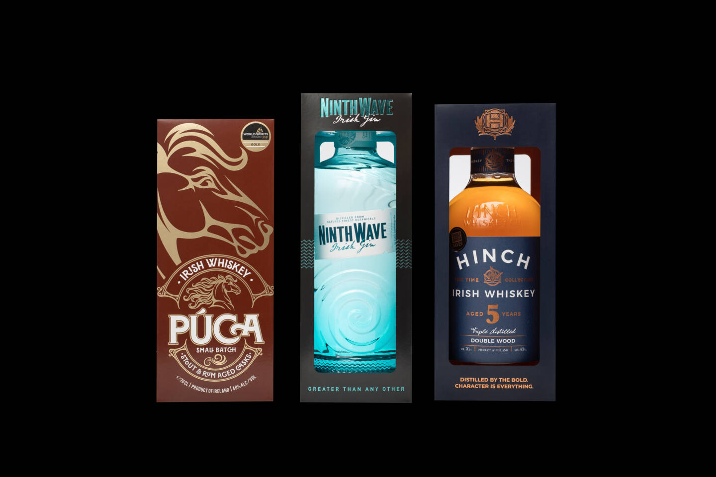 Three bottles of Irish spirits: Púca Irish Whiskey, Ninth Wave Irish Gin, and Hinch Irish Whiskey, presented in their packaging. Three bottles of Irish spirits: Púca Irish Whiskey, Ninth Wave Irish Gin, and Hinch Irish Whiskey, presented in their packaging.