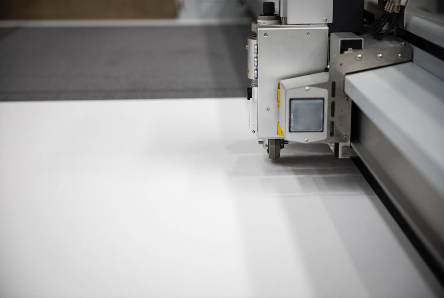 Close-up of a Z&uuml;nd cutting system's head with a wheel and laser pointer on a white surface.