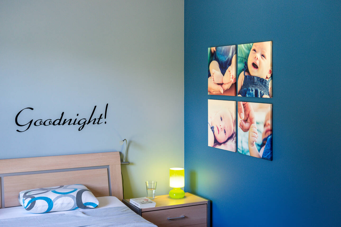Een slaapkamer met de tekst 'Goodnight!' en vier canvasfoto's van baby's aan de muur. Een slaapkamer met de tekst 'Goodnight!' en vier canvasfoto's van baby's aan de muur.