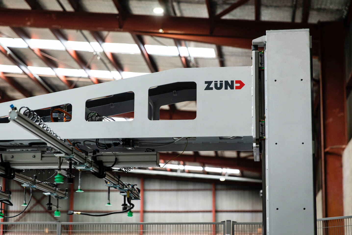 Close-up of a Zünd cutting system's gantry with the Zünd logo visible, showing its industrial design and internal components. Close-up of a Zünd cutting system's gantry with the Zünd logo visible, showing its industrial design and internal components.